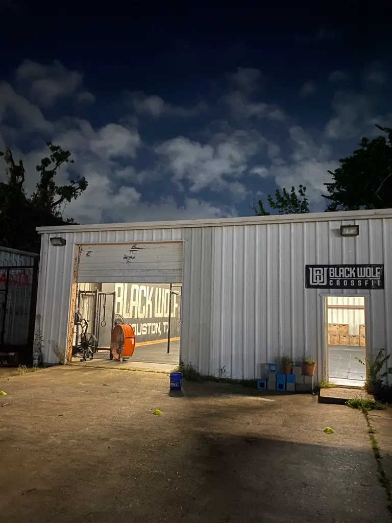 Black Wolf CrossFit garage doors lit up at dusk